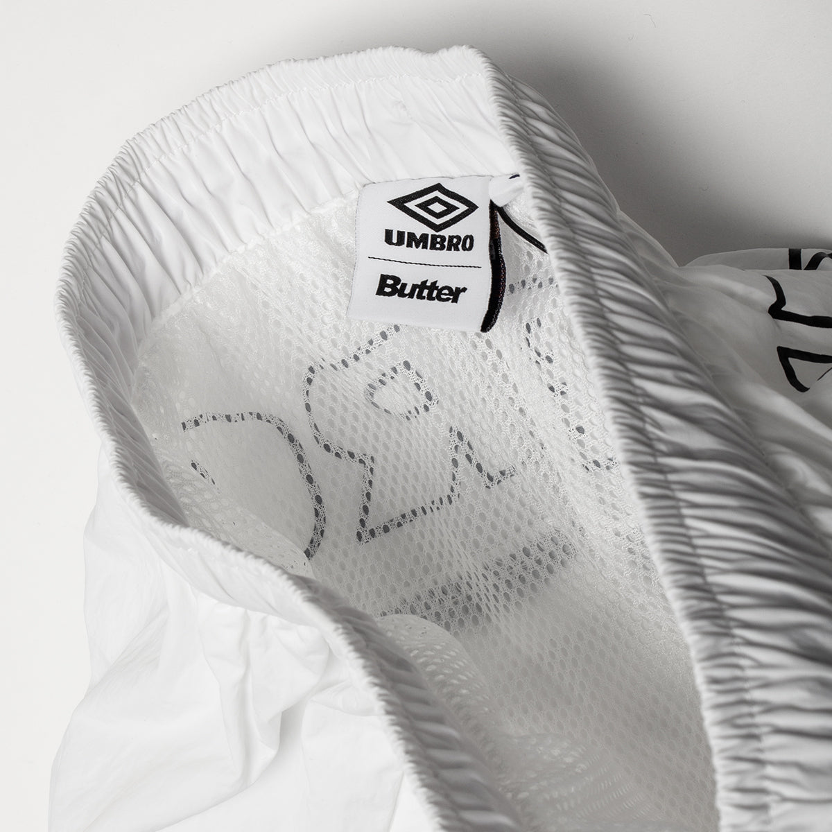 Butter Goods - Long Track Shorts x Umbro
Color : White