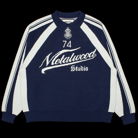 Metalwood - Knit Football Top
Color : Navy
Materials : 100% Cotton
Jacquard knit
Ribbed cuffs and hem
Embroidered details
Oversized fit