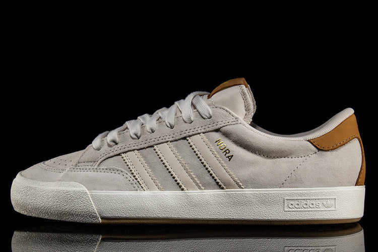 Adidas - Nora
Style # JP8594
Color : Aluminum / Core White / Gold Metallic