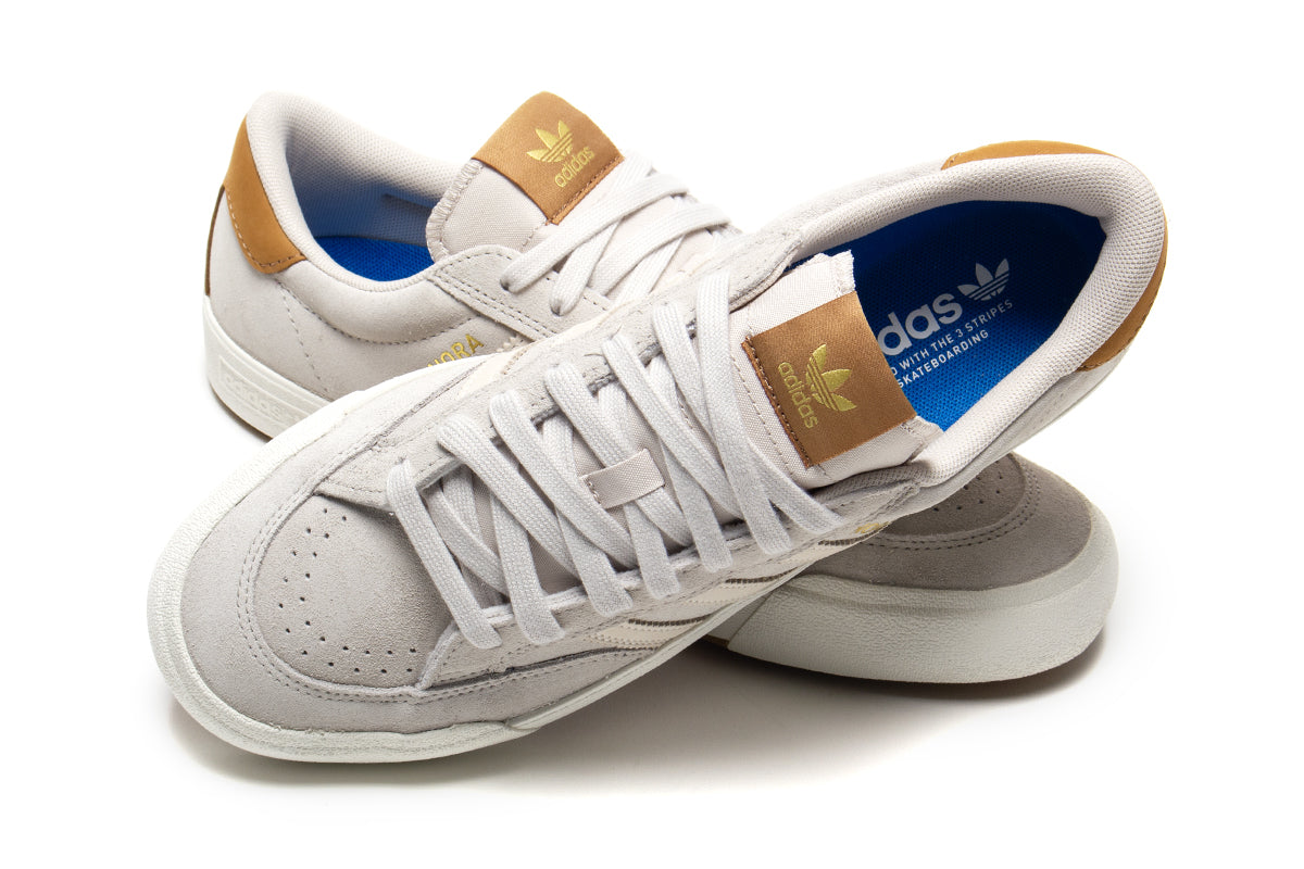 Adidas - Nora
Style # JP8594
Color : Aluminum / Core White / Gold Metallic