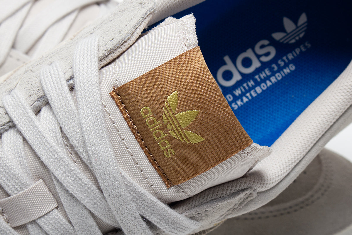 Adidas - Nora
Style # JP8594
Color : Aluminum / Core White / Gold Metallic